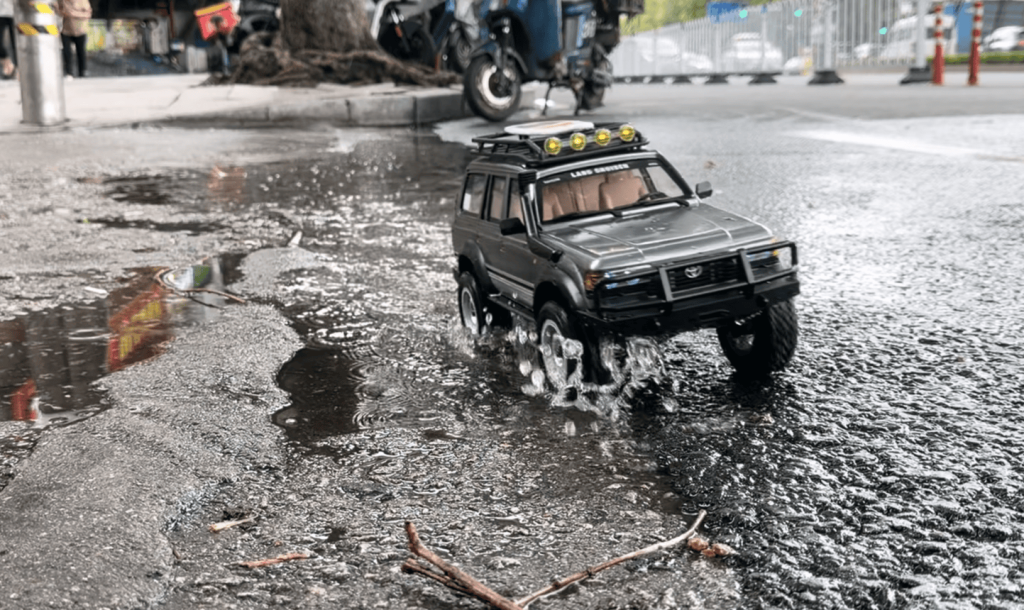 JXC 1:12 LC80 crawler wading through shallow water up to half wheel height
