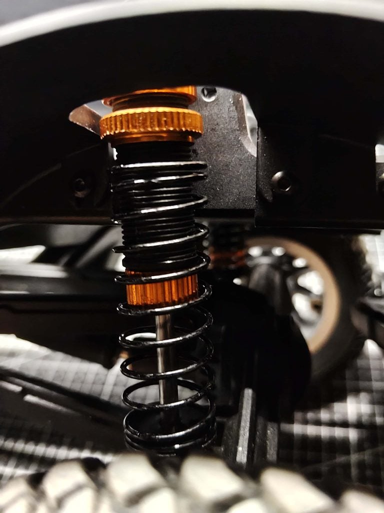 Nine-hole adjustable oil-filled shock absorber close-up on JXC 1:12 LC80 chassis