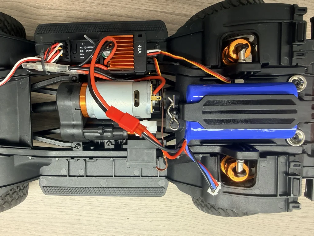JXC LC80 1/12 RC crawler chassis underside with motor, ESC and battery for electrical safety review.