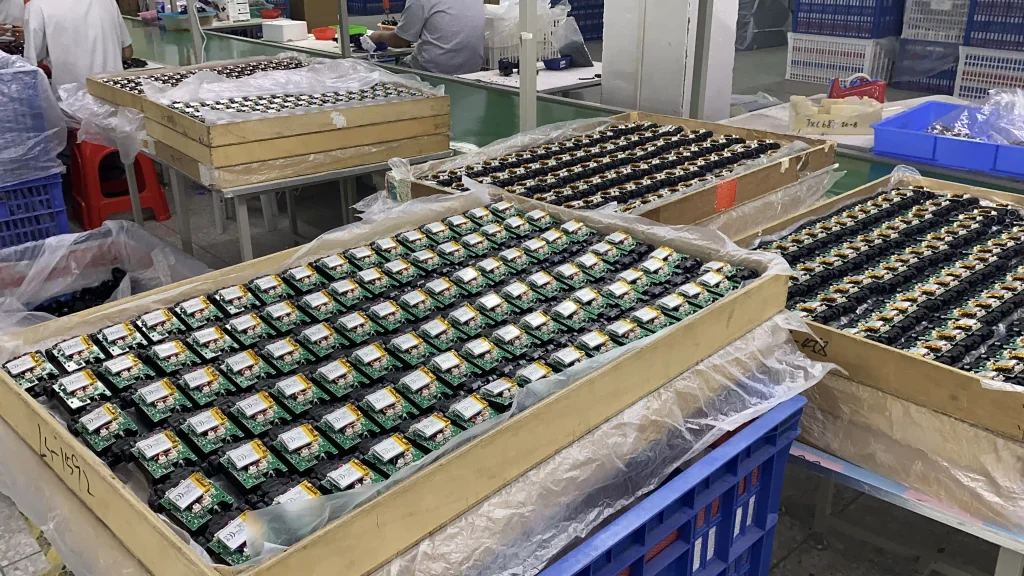 JXC batch production: stacked "supra" 1:43 RC drift car retail boxes on factory floor.	