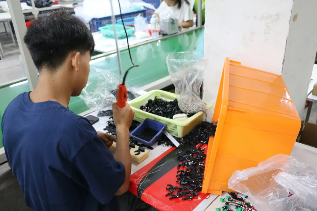 Factory worker assembling RC toy parts during quality control