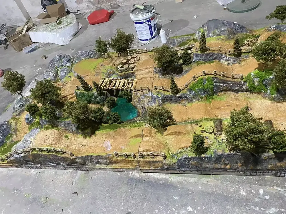 Mid-size mountain diorama track with bridge, stream and fences, photographed at the JXC Model factory