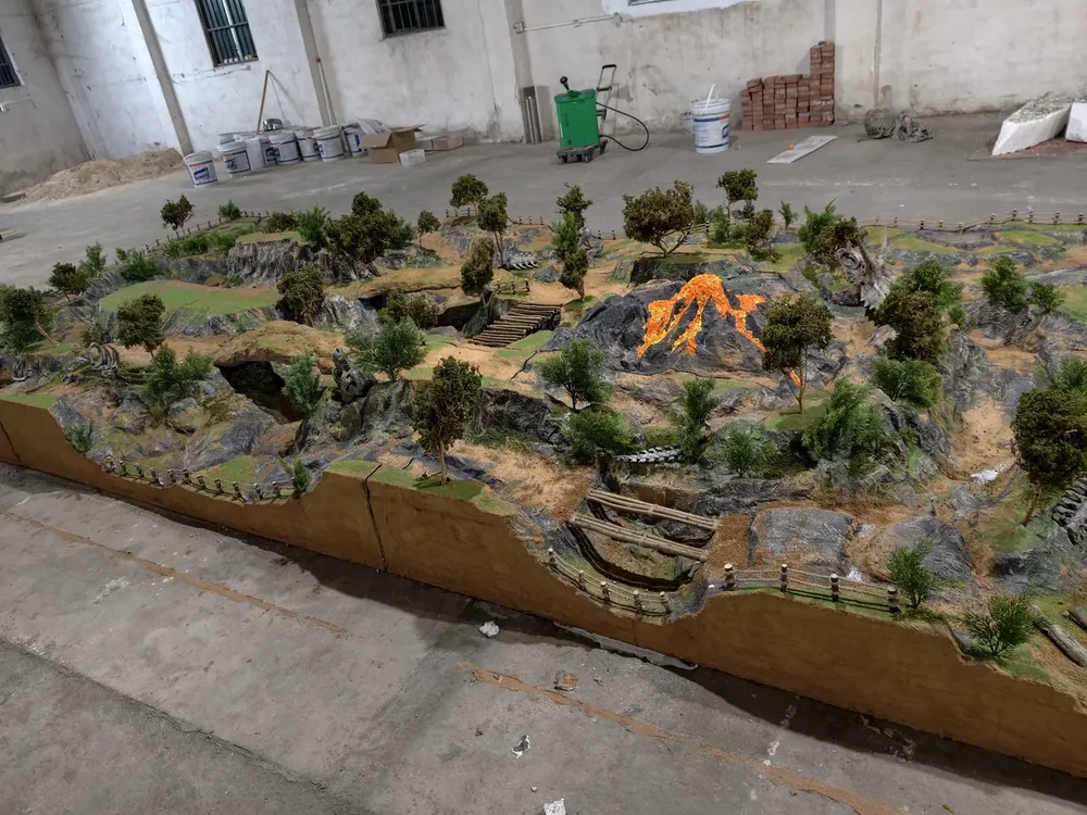Volcano-themed indoor RC diorama track built by JXC Model, photographed at the factory